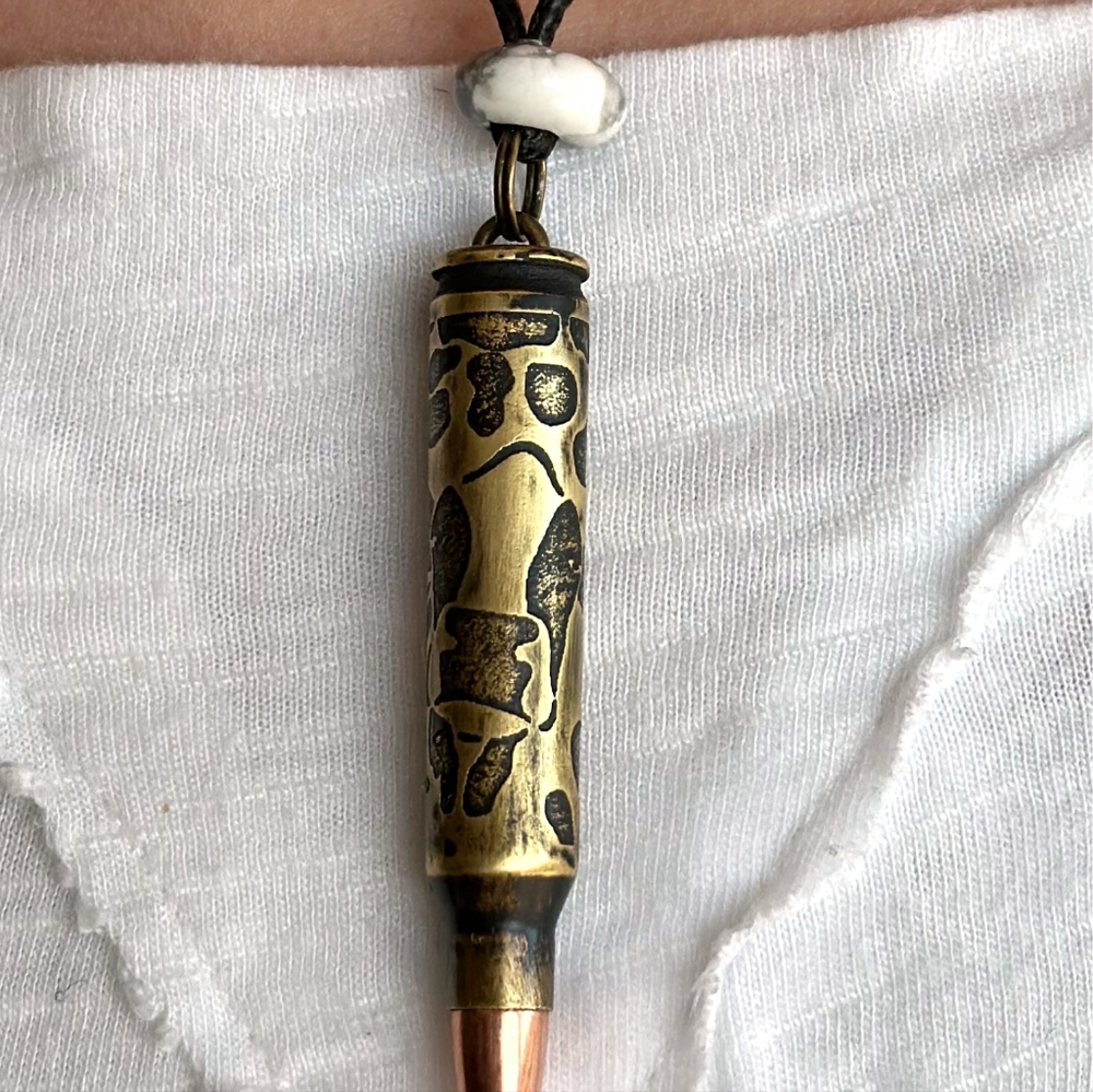 Engraved .223 Bullet with tip. Cow design with spots. 18" Necklace in black.